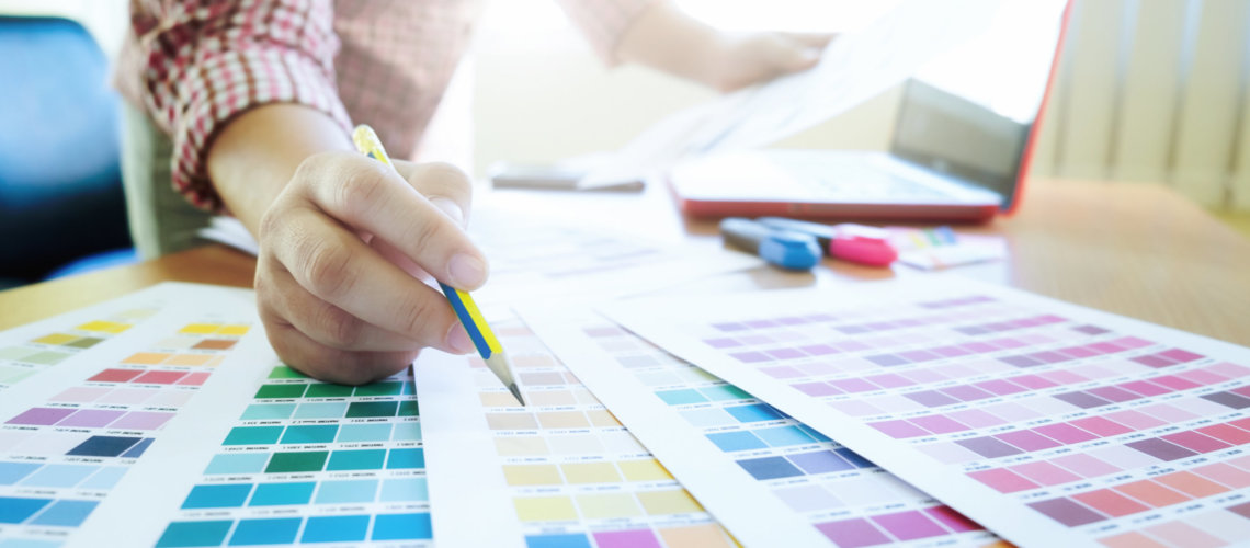 Woman working with color samples for selection. Graphic designer at work. Color swatch samples.